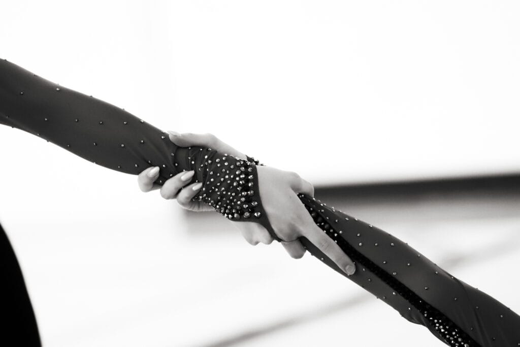 Võimlejate üksteist toetamas – lähedane detailikaader koostööst ja usaldusest esinemise ajal.